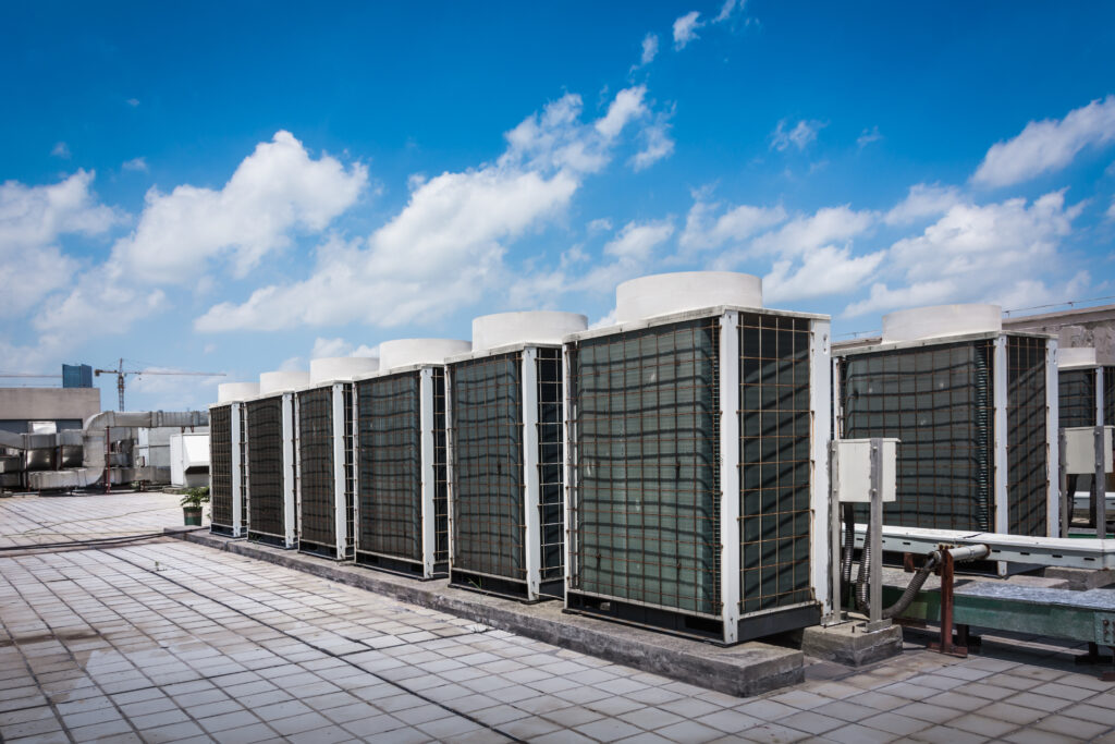 a row of air conditioners sitting on top of a roof